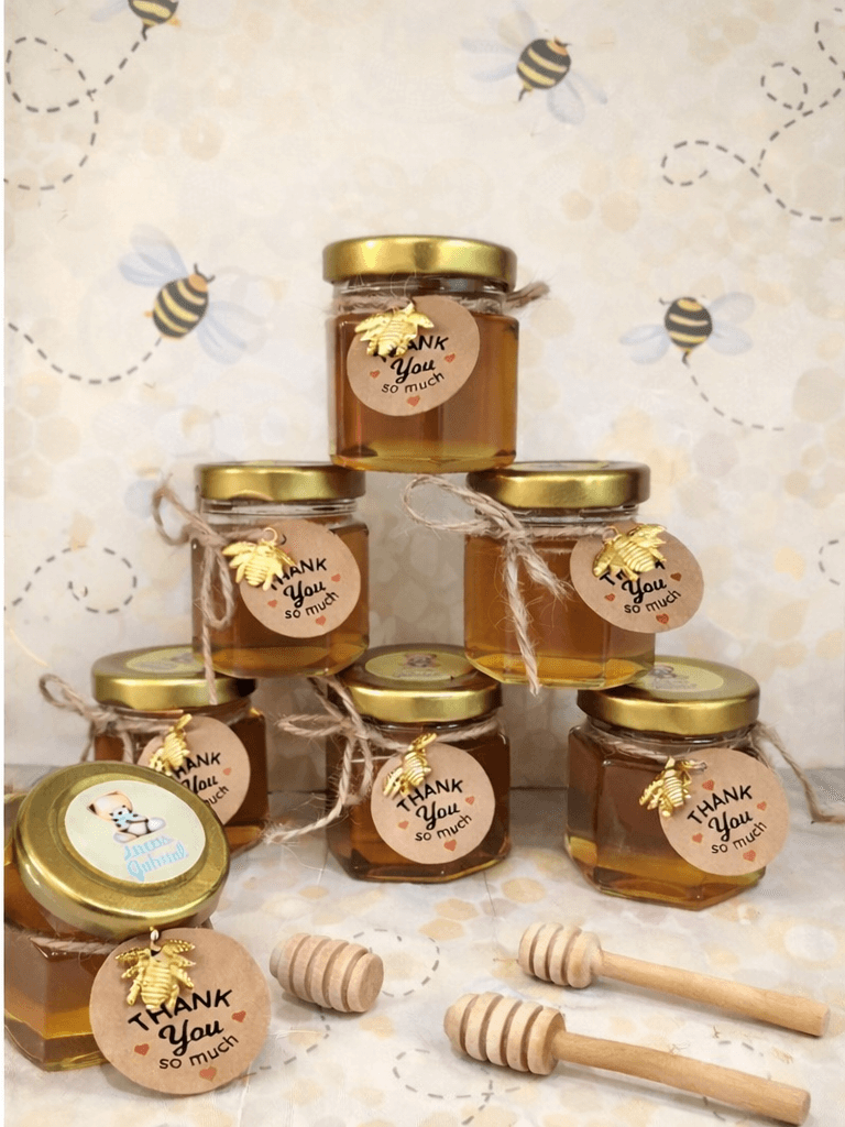 miel Mini botes de miel con palo personalizados para comunión con etiqueta decorativa y detalle de abeja, listos para regalar a invitados.